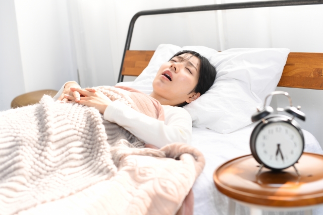 口を開けて口呼吸の状態で寝ている女性の写真