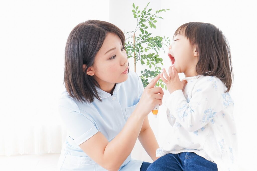 歯科衛生士が子どもの口腔内を確認している様子の画像