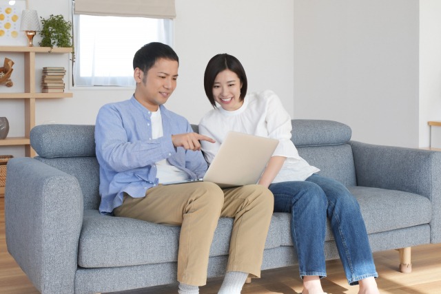 歯列矯正について、男女がパソコンを見ながら笑顔で話し合っている様子の画像