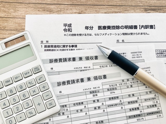 医療費控除をイメージする書類と電卓の画像