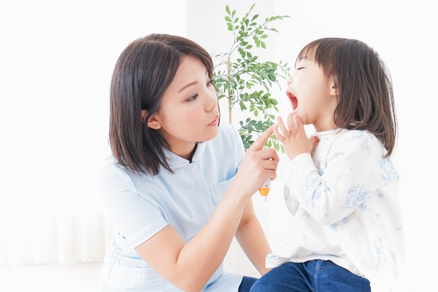 歯科衛生士が子どもの歯並びを確認している画像